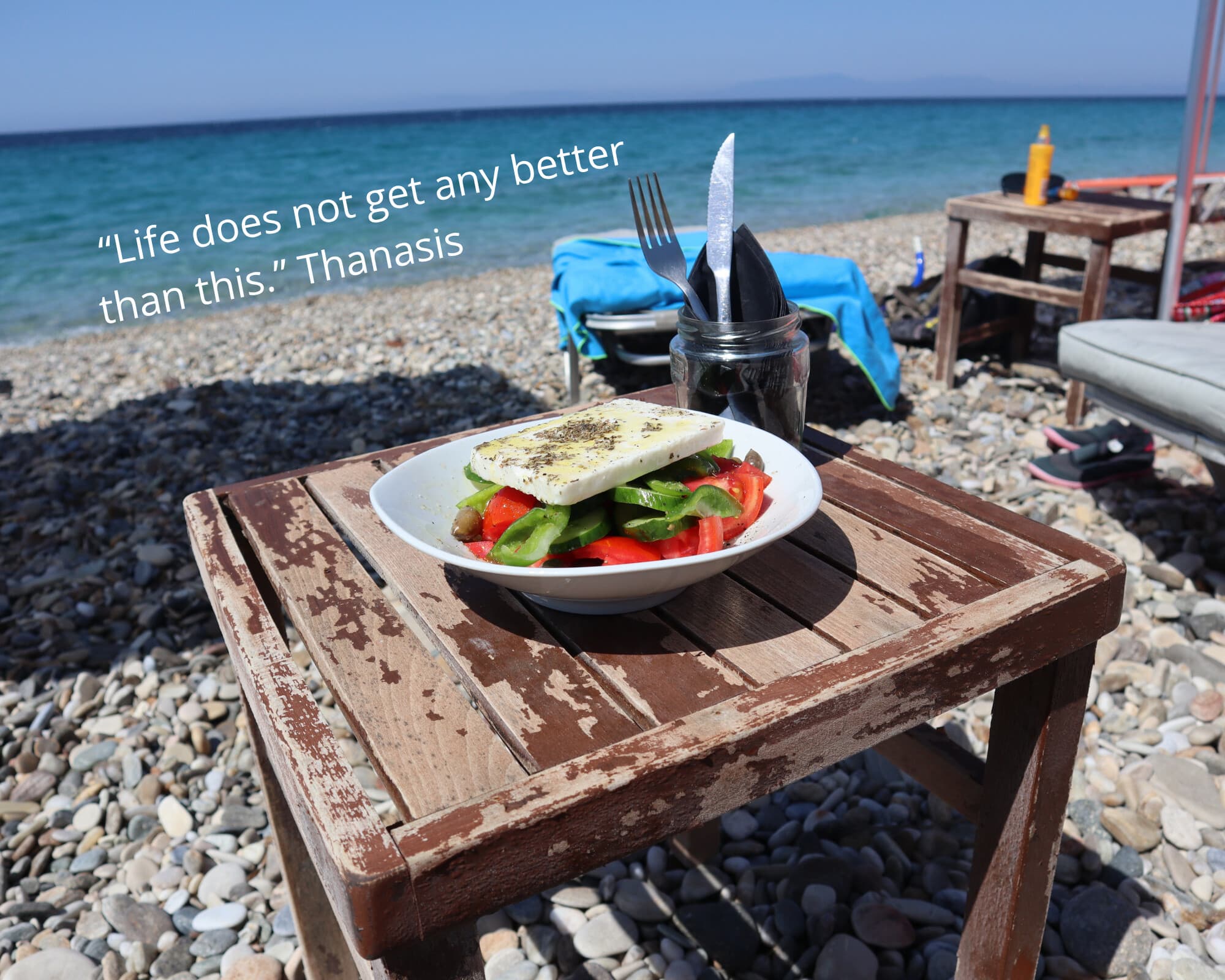 A Greek salad on a beach taverna table by the sea - Monobrow Day Tours
